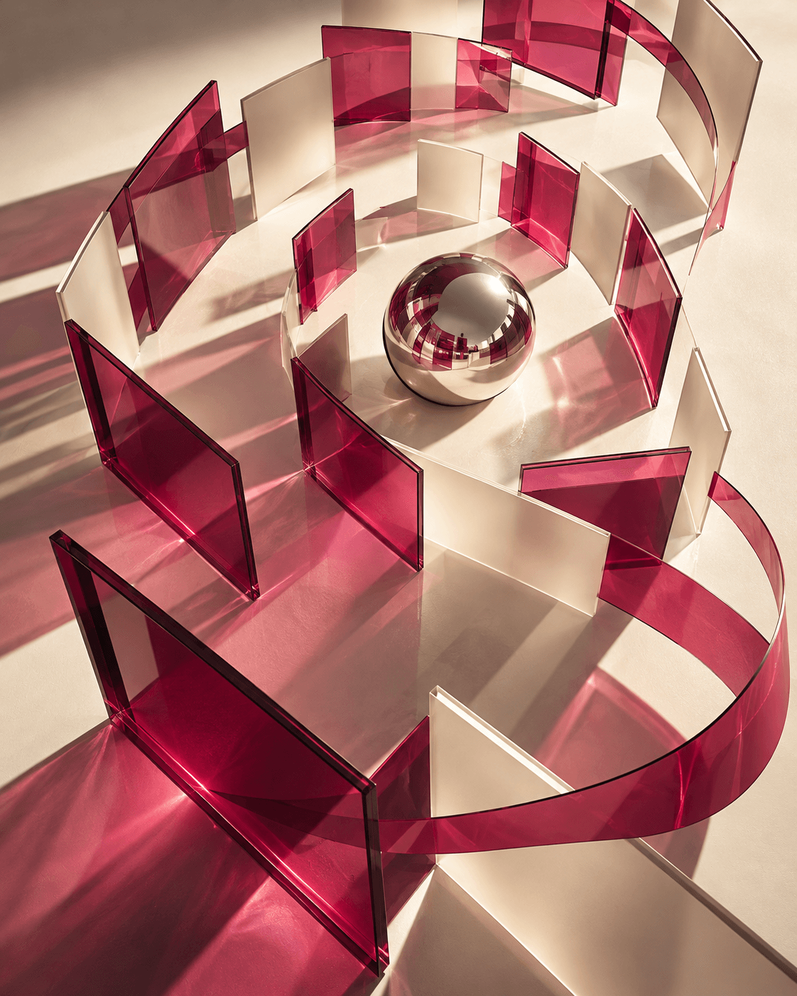 Sculptural raspberry and ivory content frames orbiting a chrome sphere